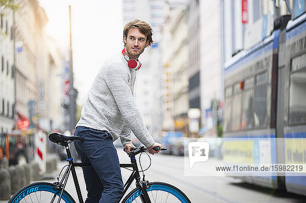 Portrait of young man with bicycle in the city