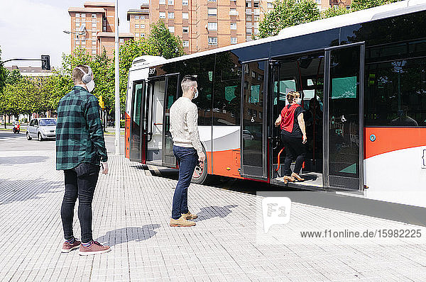 Passengers wearing protective masks getting into public bus  Spain