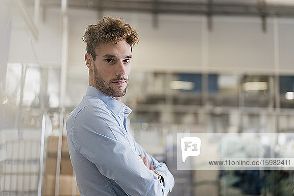 Portrait of a confident young businessman in a factory