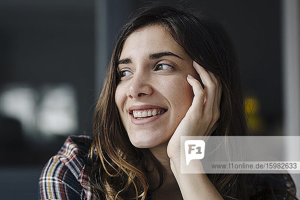 Porträt einer glücklichen jungen Frau mit Blick in die Ferne