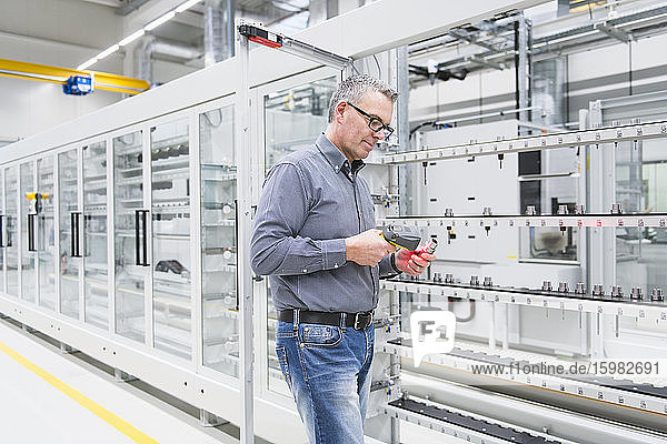 Man using barcode scanner on a product in a factory