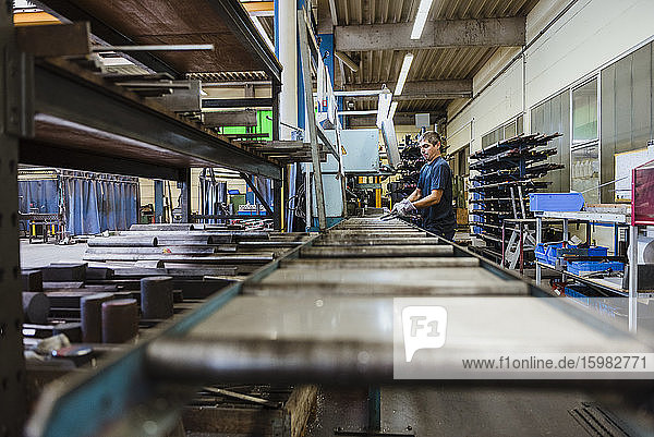 Ein Mann arbeitet an einer Maschine in einer metallverarbeitenden Fabrik