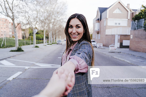 Porträt einer glücklichen Frau  die auf der Straße die Hand hält