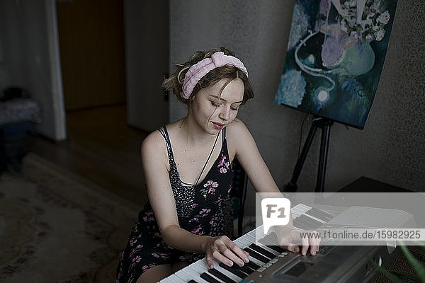 Frau spielt zu Hause Keyboard