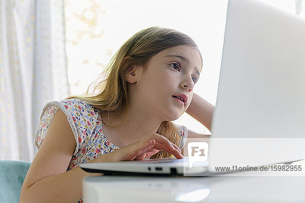 Girl (6-7) using laptop during remote learning