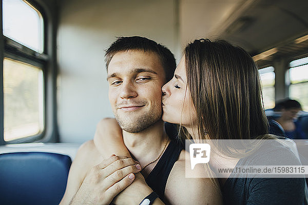 Junges Paar küsst sich im Zug