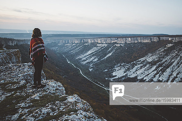 Ukraine  Krim  Junge Frau mit Plaid bedeckt schaut auf Canyon