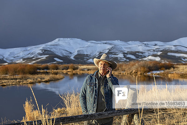 USA  Idaho  Sun Valley  älterer Mann in Cowboy mit Smartphone