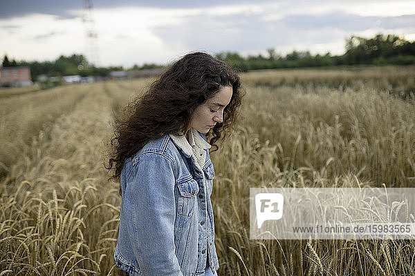 Russia  Omsk  Young woman standing in wheat field