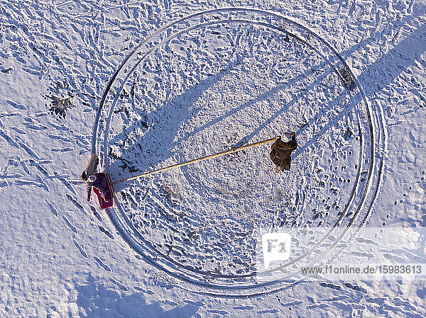Finnland  Kuopio  Blick von oben auf Mutter und Tochter beim Spielen im Schnee