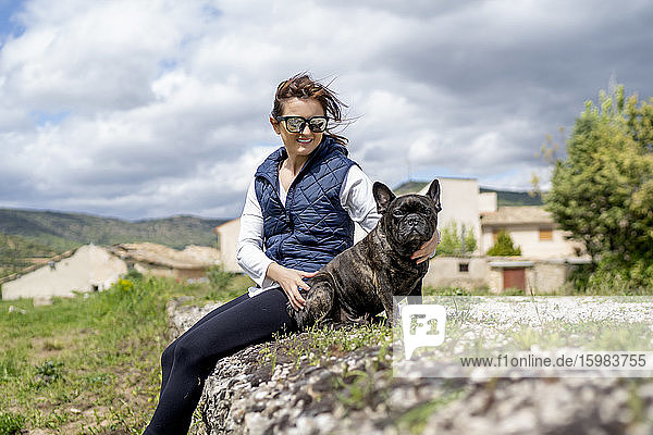 Portrait of woman and her bulldog sitting outdoors  Castilla La Mancha  Spain