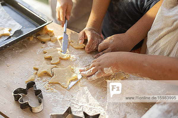 Crop view of children cutting out cookies