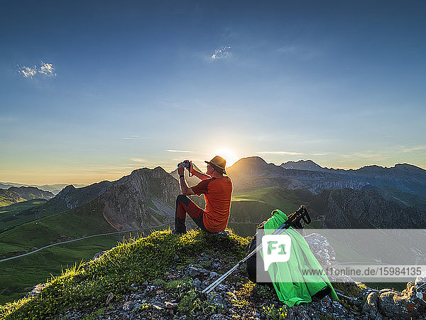 Seitenansicht eines älteren Mannes  der auf einem Bergpass sitzend fotografiert  Asturien  Spanien