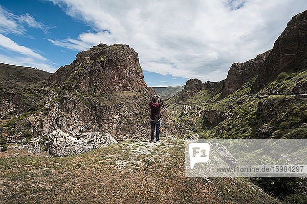 Georgia  Samtskhe-Javakheti  Male tourist photographing Vardzia cave monastery