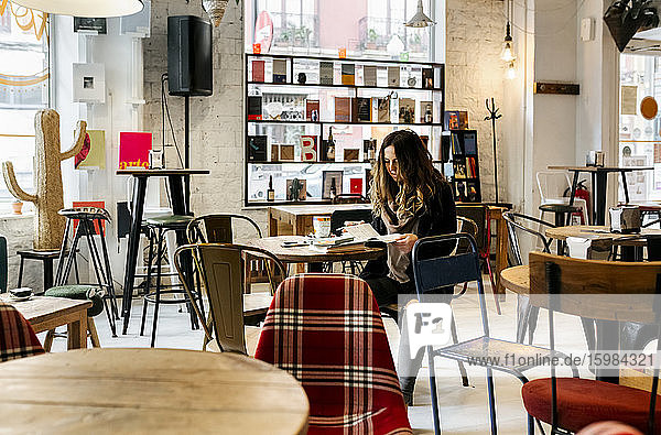 Frau liest ein Buch in einem Café