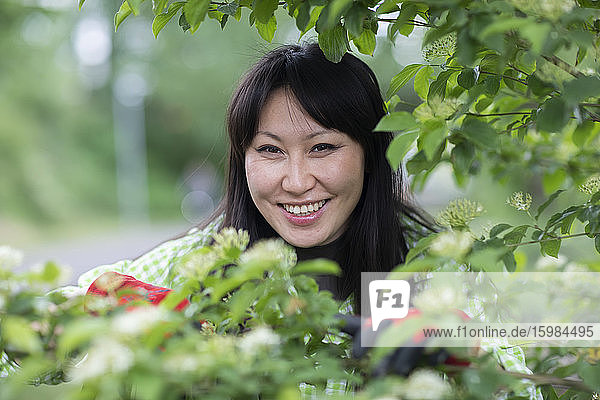 Smiling woman looking at camera in urban garden