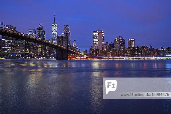 USA  New York  New York City  East River and Brooklyn Bridge at purple dawn with Manhattan skyline in background