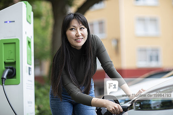 Carsharing  woman charging an electric car