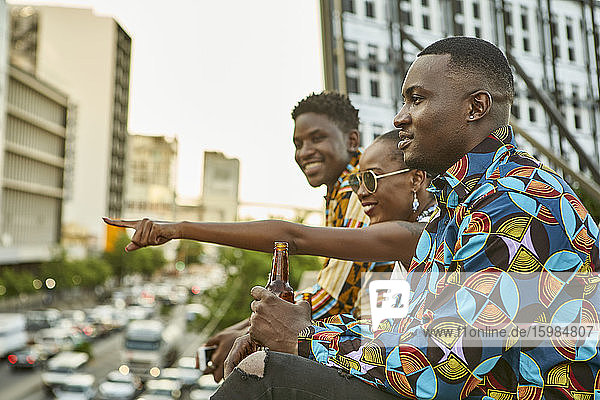 Freunde sitzen auf einer Dachterrasse in der Stadt und trinken Bier  Maputo  Mosambik