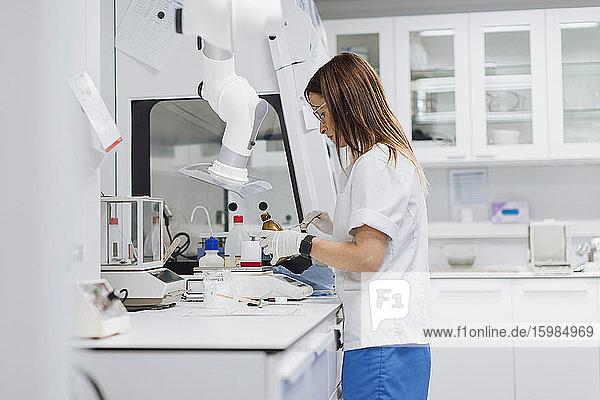 Female scientist with long brown hair working at laboratory
