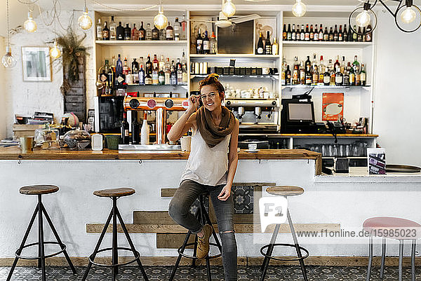 Frau benutzt Smartphone in einem Kaffeehaus