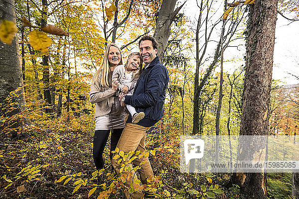Porträt einer lächelnden Familie im Wald im Herbst