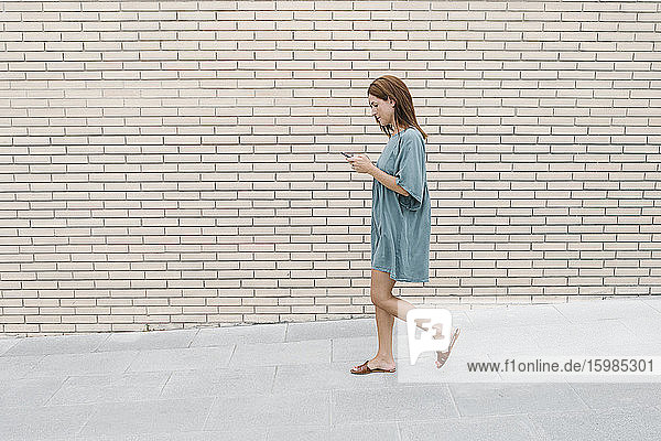 Frau benutzt Smartphone beim Gehen auf der Straße