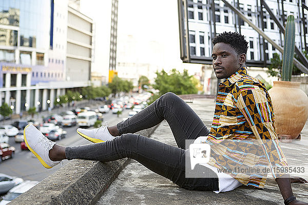 Junger Mann in gemustertem Hemd auf einer Dachterrasse in der Stadt  Maputo  Mosambik