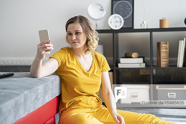Woman using smartphone in living room at home