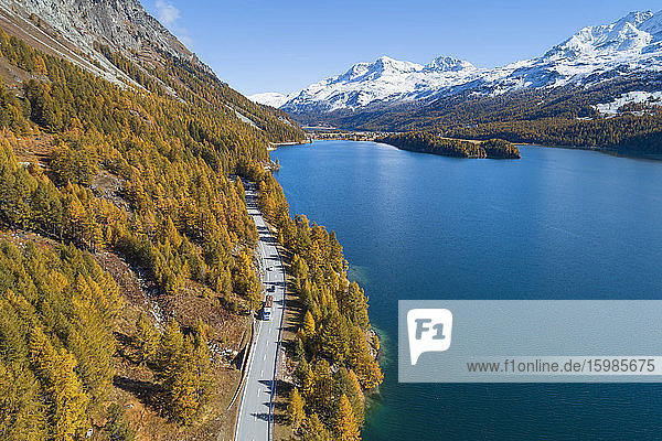 Switzerland  Canton of Grisons  Saint Moritz  Drone view of highway stretching along shore of Lake Sils in autumn