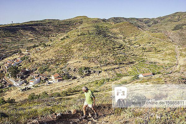 Spain  Canary Islands  La Gomera  Two hikers ascending Table Mountain with village in background