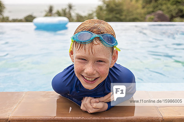 Close-up portrait of smiling boy playing in swimming pool  Thailand  Asia