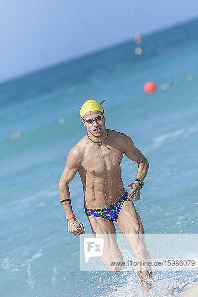 Männlicher Schwimmer beim Laufen am Strand in Dubai  Vereinigte Arabische Emirate