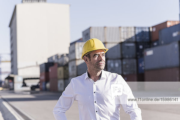 Porträt eines Geschäftsmannes mit Schutzhelm auf einem Industriegelände