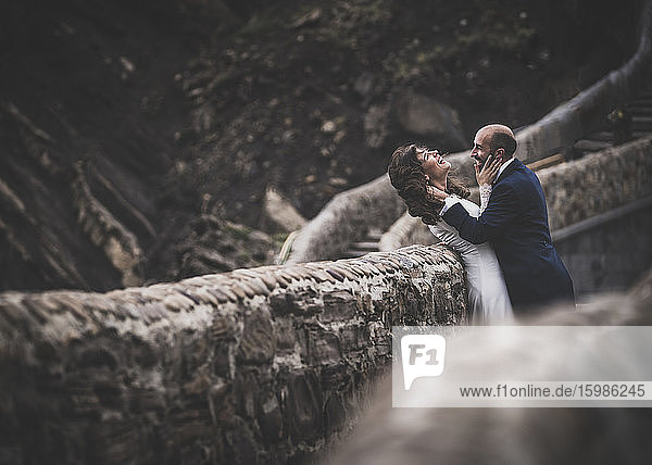 Lachendes Brautpaar auf einer Brücke  Gaztelugatxe  Spanien