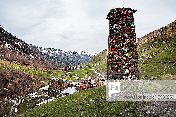 Georgien  Swanetien  Ushguli  Alter Backsteinturm mit Blick auf ein mittelalterliches Bergdorf