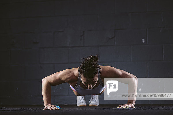 Woman practicing push-up exercise at gym