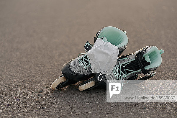 Nahaufnahme einer Gesichtsmaske auf Inline-Skates in einem Skateboard-Park