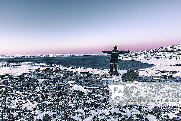 Mann in winterlicher Küstenlandschaft am Lakse Fjord  Lebesby  Norwegen
