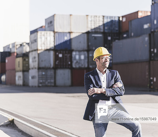 Portrait of smiling businessman wearing safety helmet at industrial site