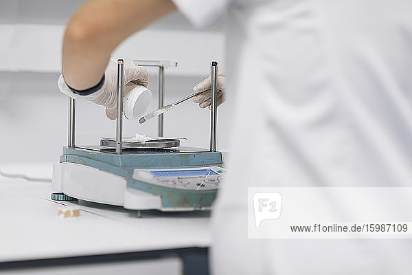 Female doctor weighing sample at laboratory