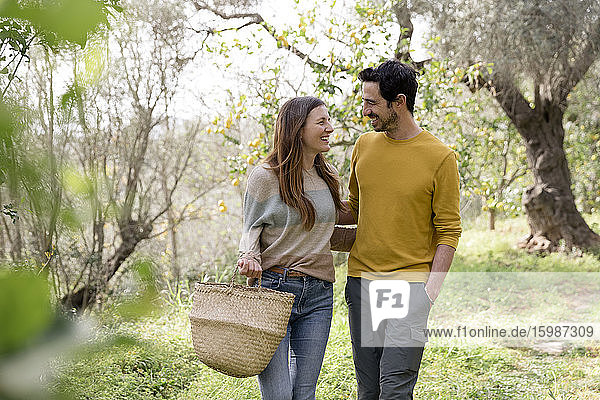 Romantisches Paar  das sich bei einem Spaziergang gegen Bäume auf einem Bauernhof ansieht