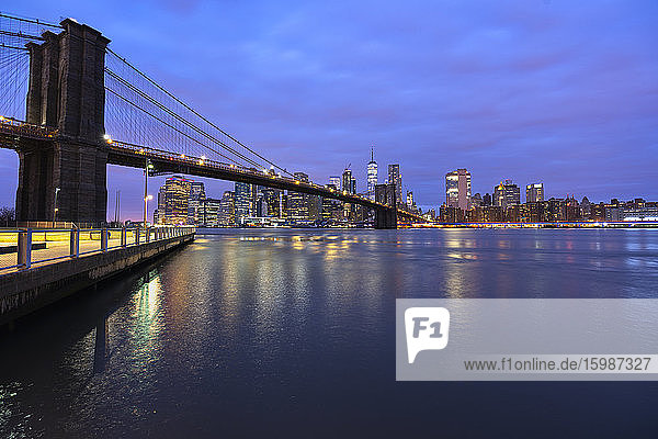 USA  New York  New York City  East River und Brooklyn Bridge in der lila Morgendämmerung mit der Skyline von Manhattan im Hintergrund