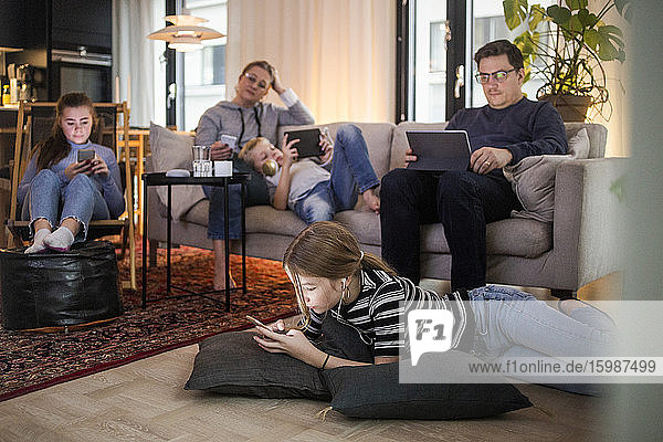 Family is using technologies in living room at modern home