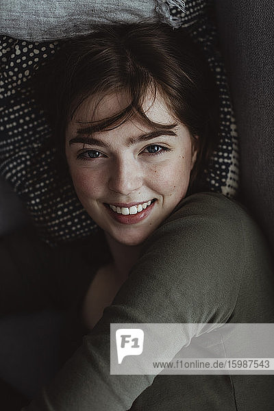 Porträt einer lächelnden Frau auf dem Sofa