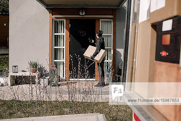 Delivery man with package at entrance of house
