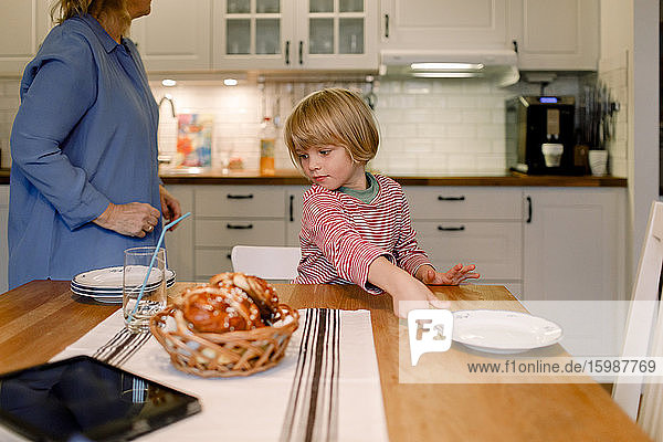 Boy with grandmother in kitchen at home