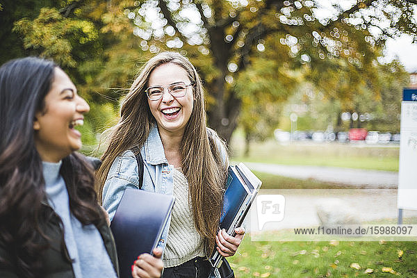 Happy young female friends in university campus