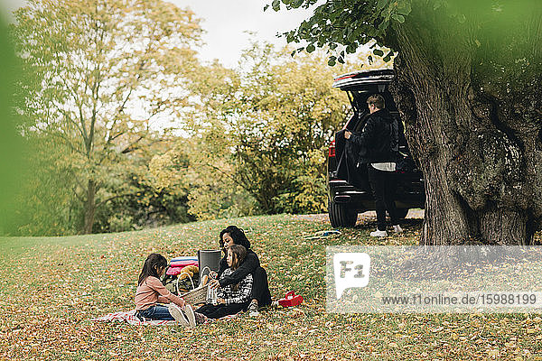 Eltern mit Töchtern genießen Picknick im Herbst