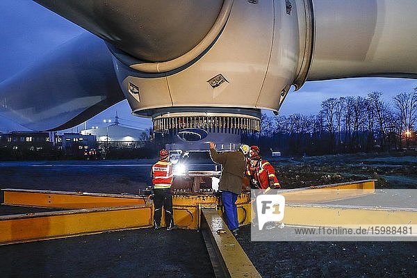 Montage einer Windkraftanlage Krane heben in der Dämmerung Rotorkranz mit Rotorblättern Bottrop Ruhrgebiet Nordrhein-Westfalen Deutschland Europa